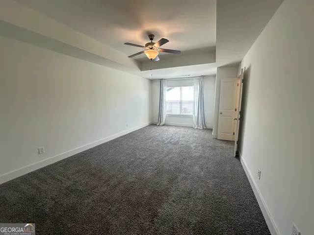 a view of a livingroom with a ceiling fan and window