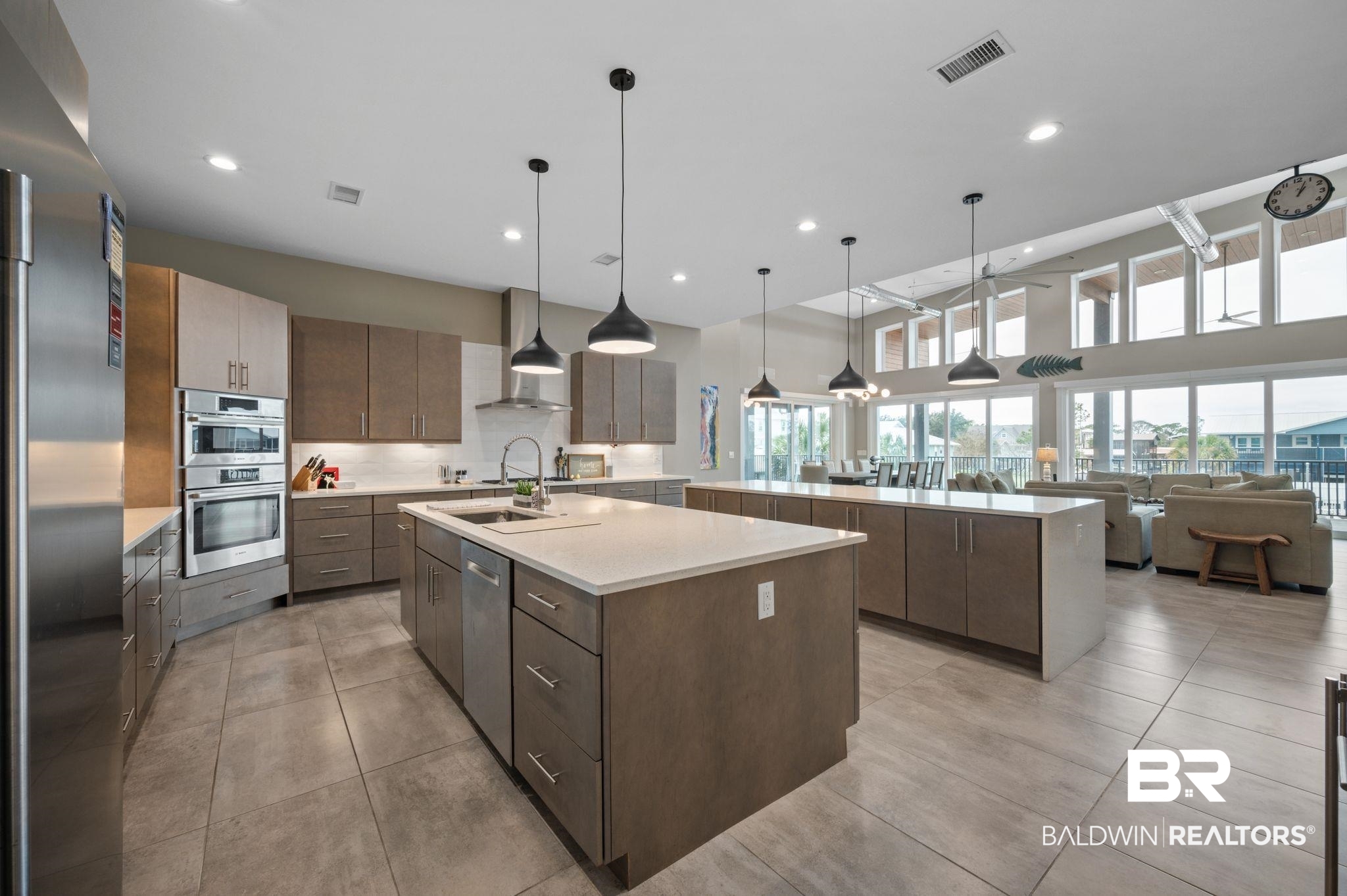 3840 Cotton Way Orange Beach, AL 36561 - Photo 16 of 75 Kitchen with a kitchen island with sink, sink, wall chimney exhaust hood, decorative light fixtures, and stainless steel appliances