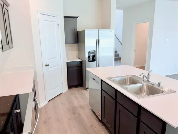 a kitchen with a sink a refrigerator and window