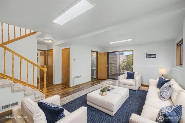 a living room with furniture and a wooden floor