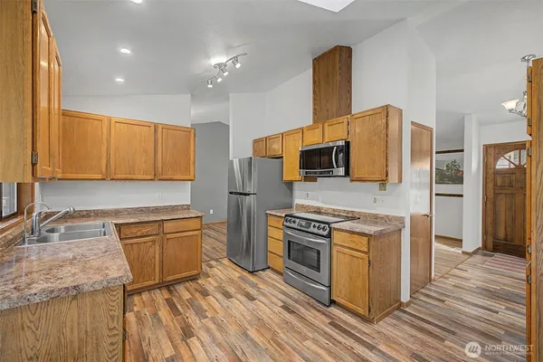 a kitchen with stainless steel appliances granite countertop a sink stove and refrigerator