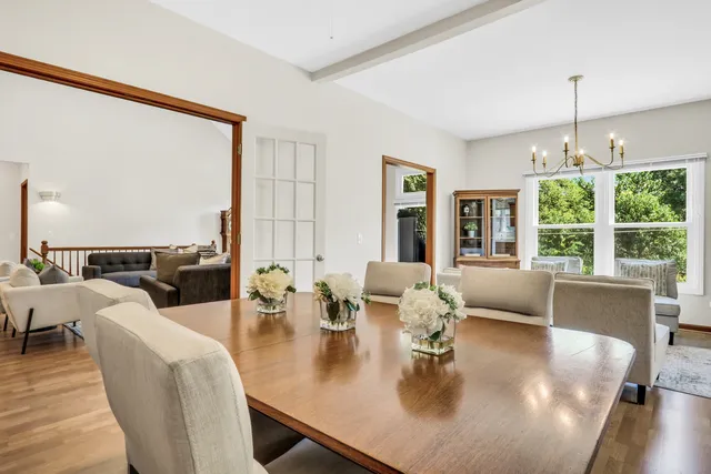 a dining room with furniture a large window and a chandelier