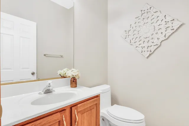 a bathroom with a sink vanity mirror and toilet