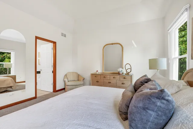 a bedroom with a bed and a dresser with mirror