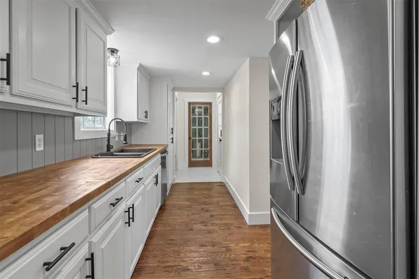a large kitchen with stainless steel appliances granite countertop a refrigerator and a sink