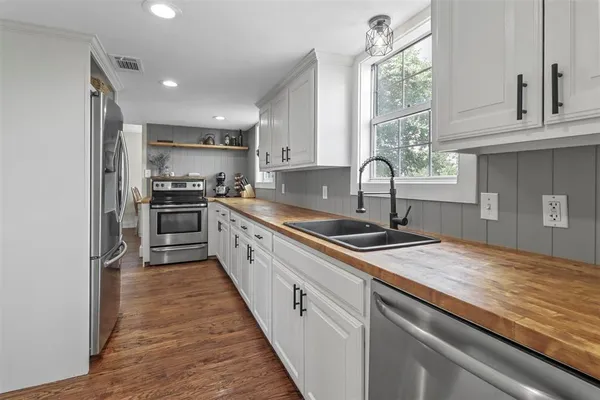 a kitchen with stainless steel appliances granite countertop a sink a stove and a refrigerator