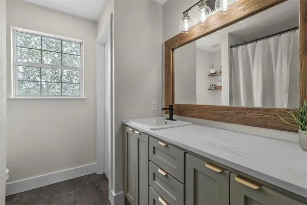 a bathroom with a granite countertop sink and a mirror