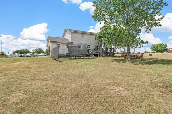 a backyard of a house with table and chairs