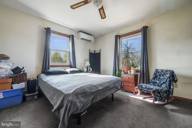 a bedroom with a bed chair and window