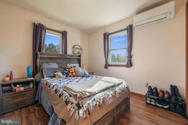 a bedroom with a bed and wooden floor