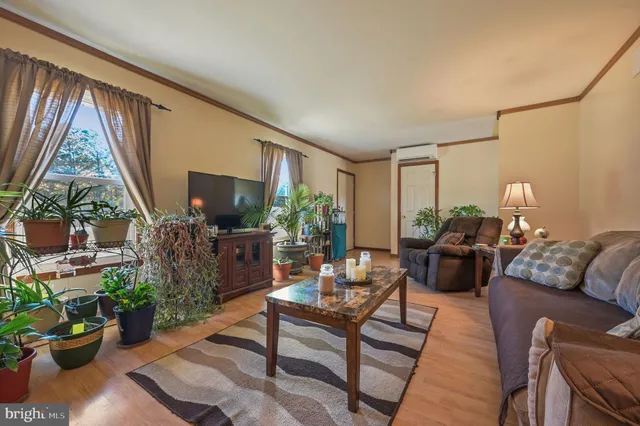 a living room with furniture a flat screen tv and a large window