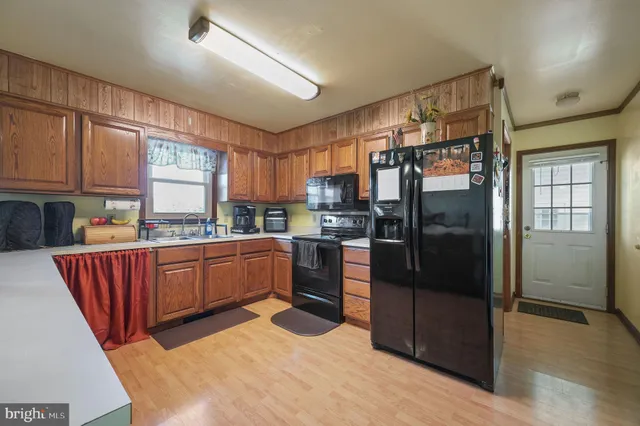a kitchen with stainless steel appliances granite countertop a refrigerator and wooden cabinets
