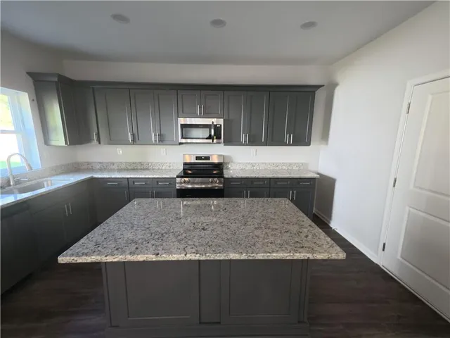 a kitchen with kitchen island a counter top space cabinets and appliances