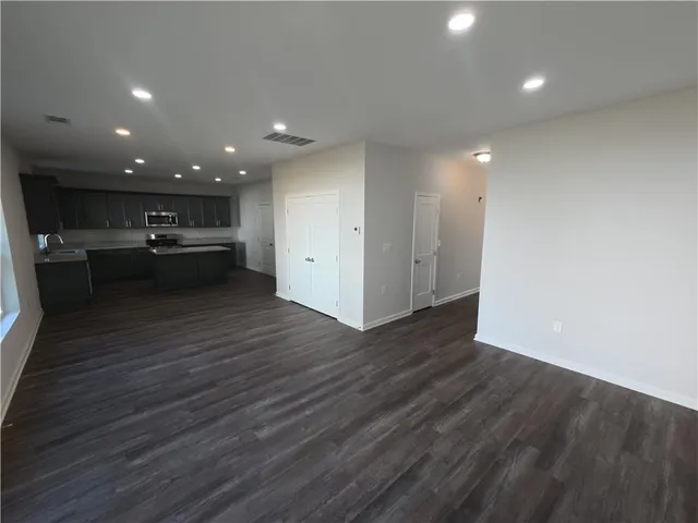 a view of a kitchen with cabinets and wooden floor
