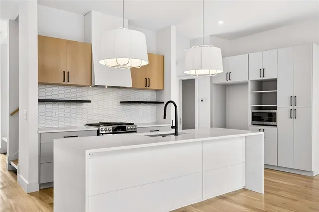 a kitchen with stainless steel appliances a stove a sink a refrigerator and cabinets