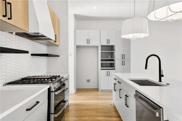 a kitchen with stainless steel appliances granite countertop a sink and a stove