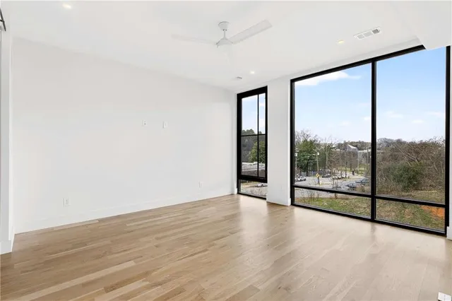 an empty room with wooden floor and sliding glass door