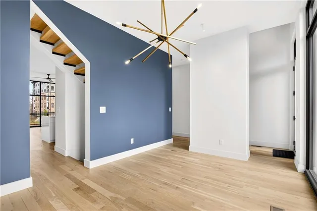 a view of a big room with wooden floor and entryway