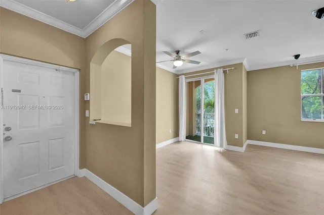 an empty room with windows and fan