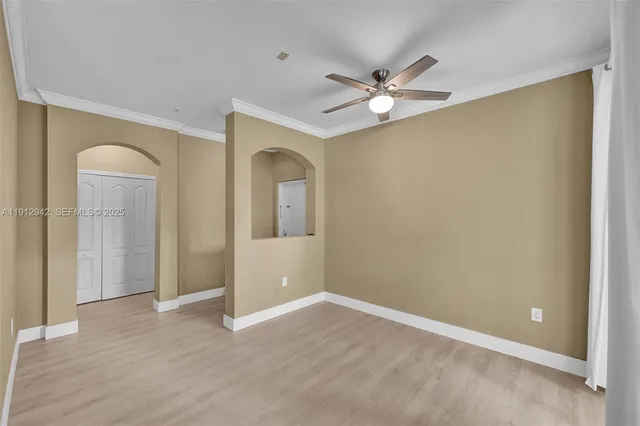 a view of a livingroom with wooden floor and a ceiling fan