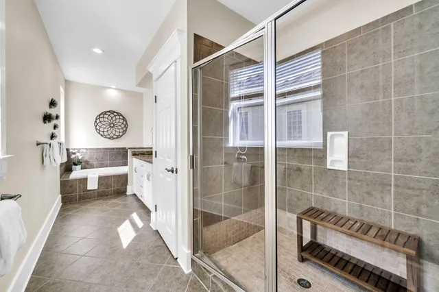 a spacious bathroom with a double vanity sink mirror and bathtub