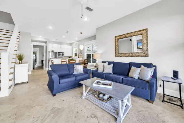 a living room with furniture and a view of kitchen