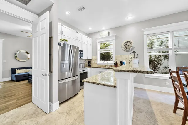 a kitchen with stainless steel appliances granite countertop a refrigerator and a stove top oven