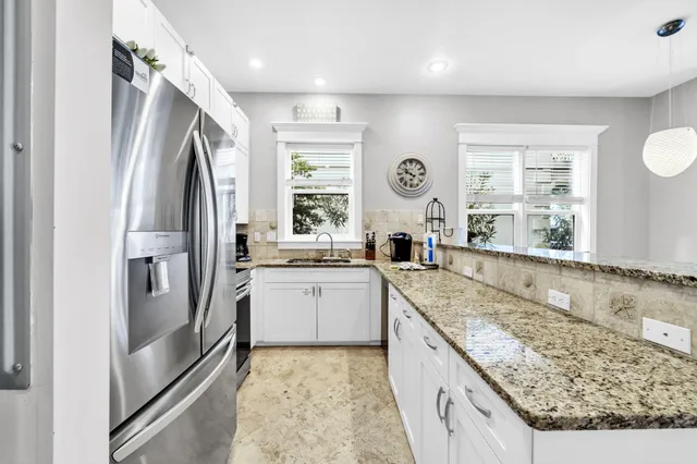 a large kitchen with granite countertop a sink window stainless steel appliances and cabinets