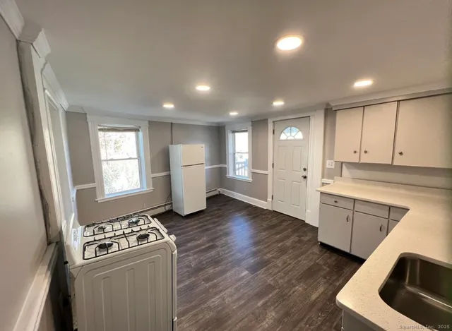 a kitchen with refrigerator and white cabinets