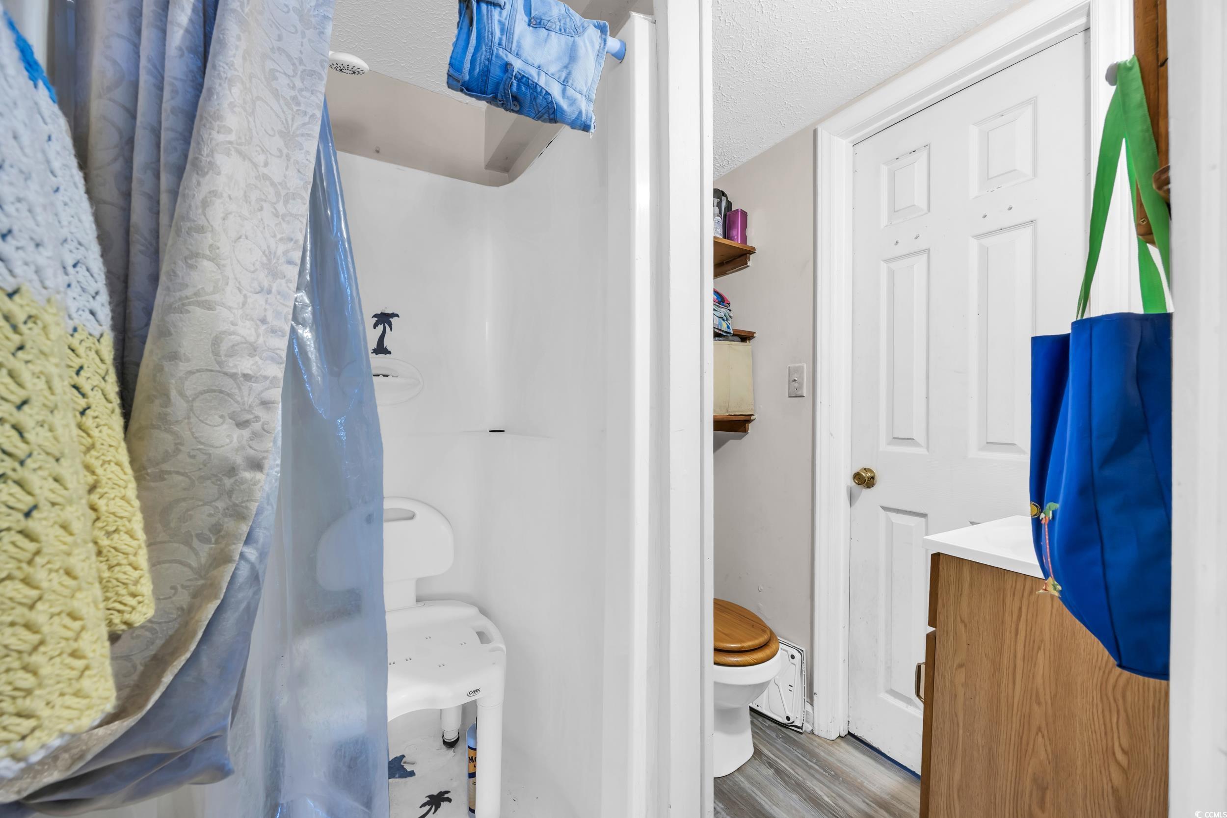 1616 Perrin Drive North Myrtle Beach, SC 29582 - Photo 30 of 40 Bathroom featuring a textured ceiling, a shower with shower curtain, wood finished floors, and vanity