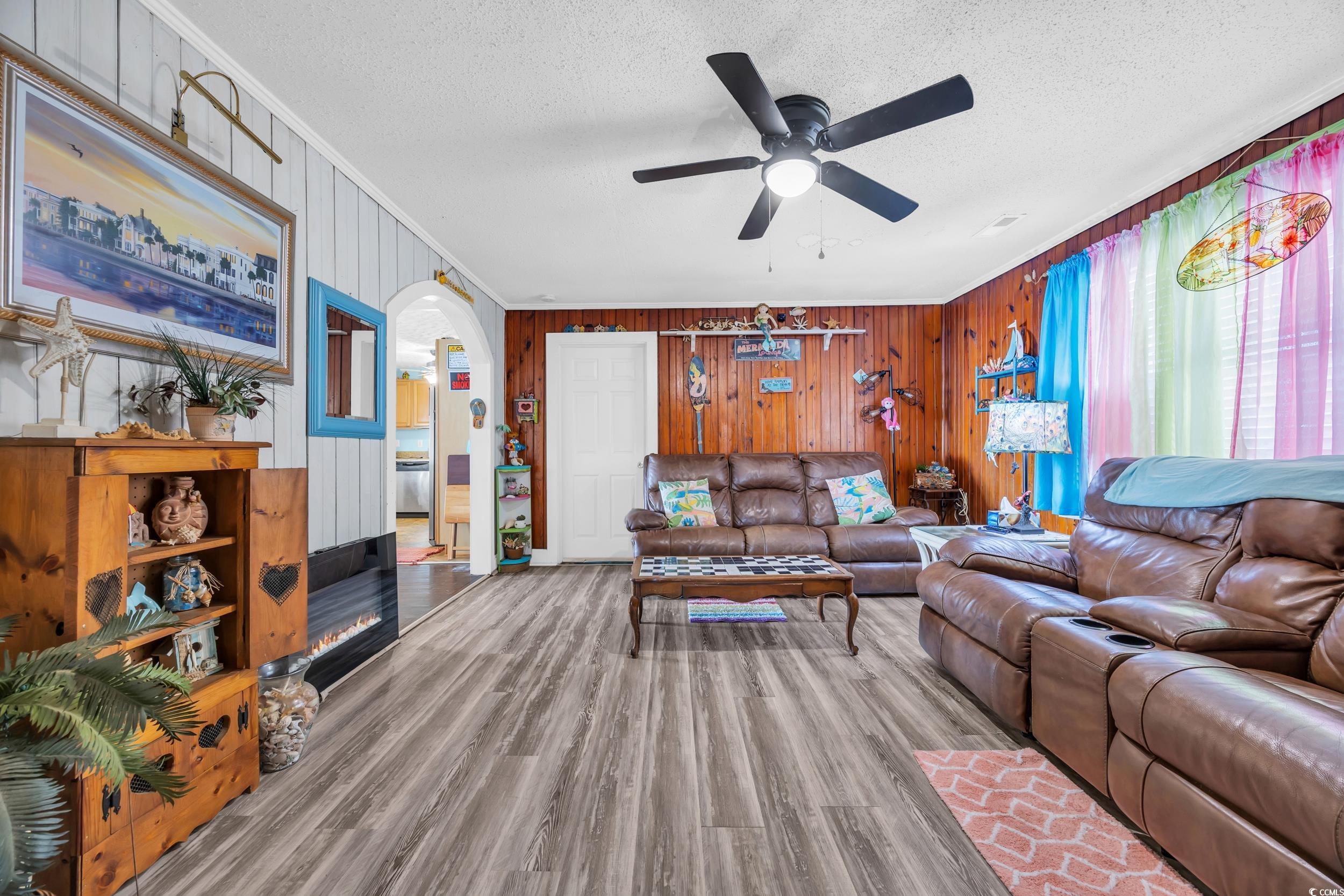 1616 Perrin Drive North Myrtle Beach, SC 29582 - Photo 5 of 40 Living room with wood walls, a textured ceiling, wood finished floors, arched walkways, and ceiling fan
