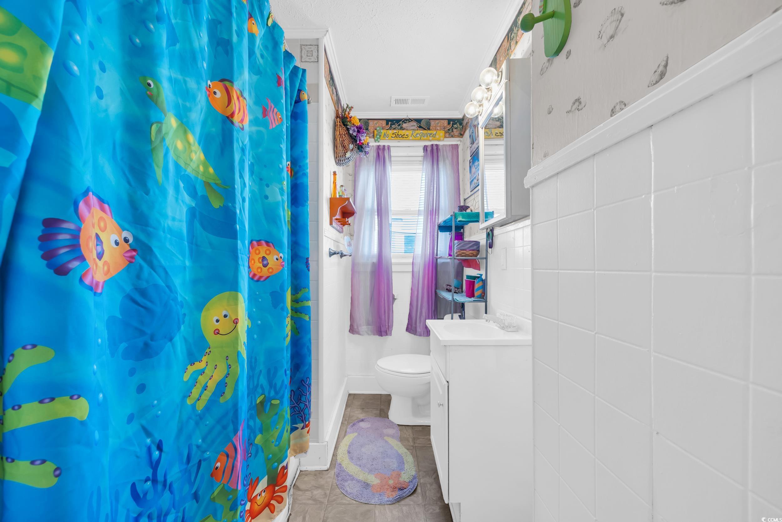 1616 Perrin Drive North Myrtle Beach, SC 29582 - Photo 7 of 40 Bathroom with curtained shower, vanity, tile walls, and tile patterned floors