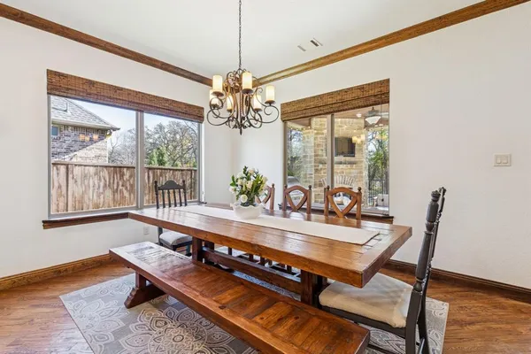 a dining room with furniture a chandelier and wooden floor