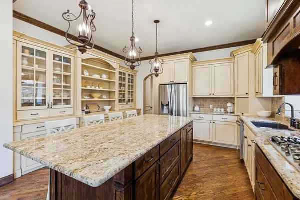 a kitchen with kitchen island granite countertop a stove and a sink