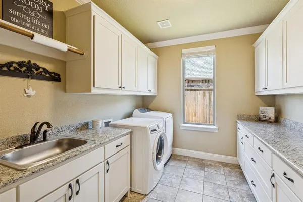 a view of a kitchen with sink dishwasher and wooden cabinets