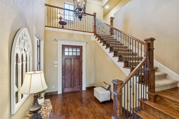 a view of staircase with wooden floor and a chandelier