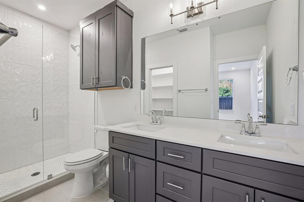 200 West 56th Street, Unit 8102 Austin, TX 78751 - Photo 11 of 13 a bathroom with a toilet a sink a mirror and vanity