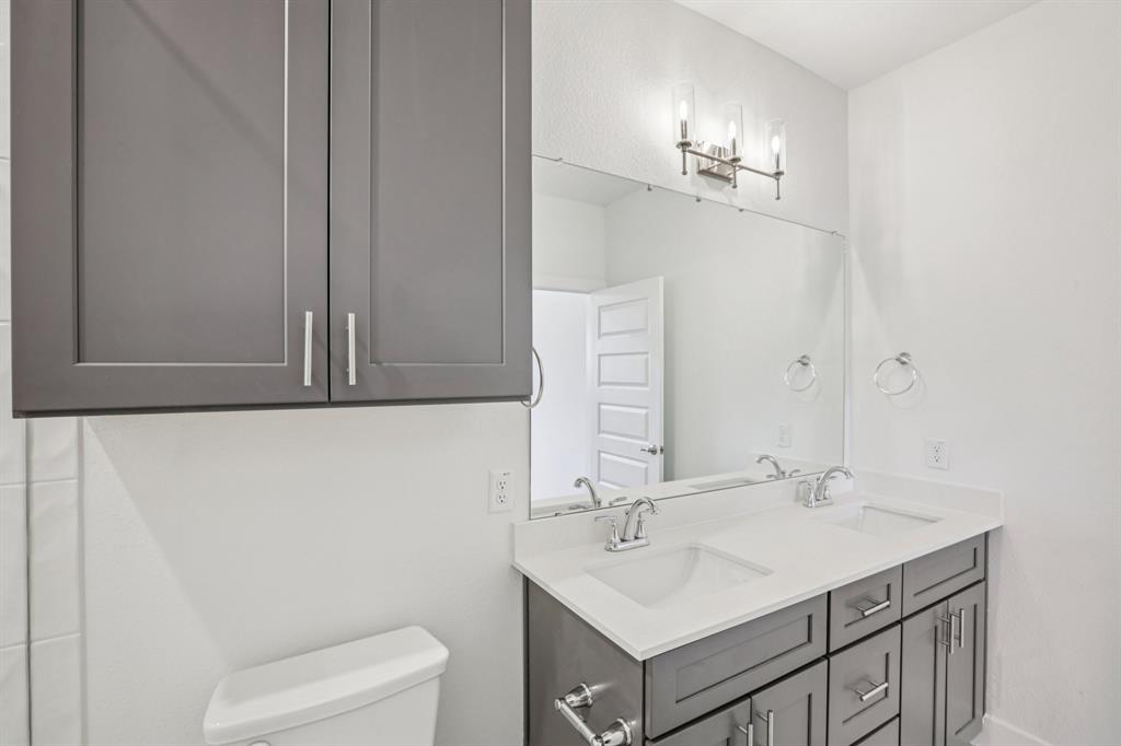 200 West 56th Street, Unit 8102 Austin, TX 78751 - Photo 12 of 13 a bathroom with a sink a toilet and a mirror