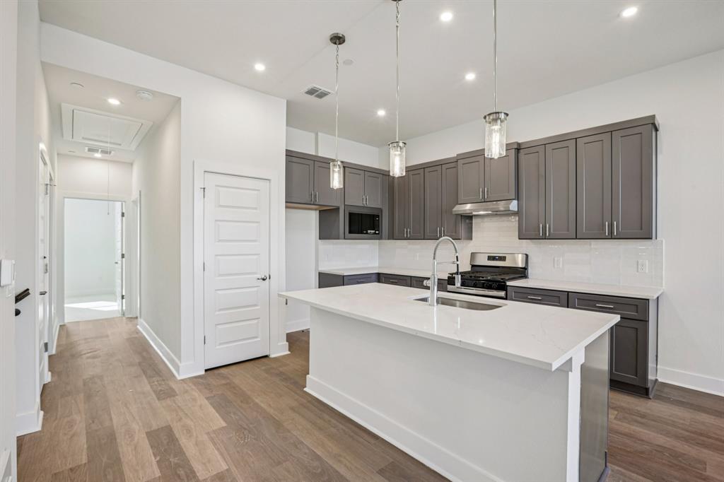 200 West 56th Street, Unit 8102 Austin, TX 78751 - Photo 4 of 13 a kitchen with kitchen island a sink stainless steel appliances and cabinets