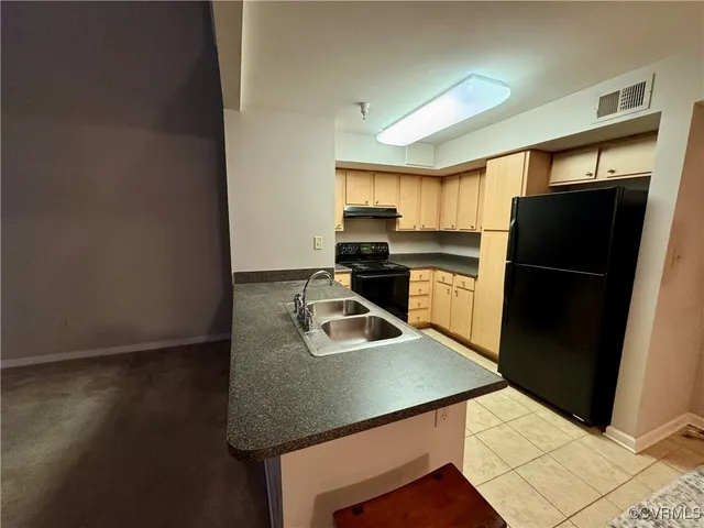 a kitchen with a refrigerator a sink and a stove