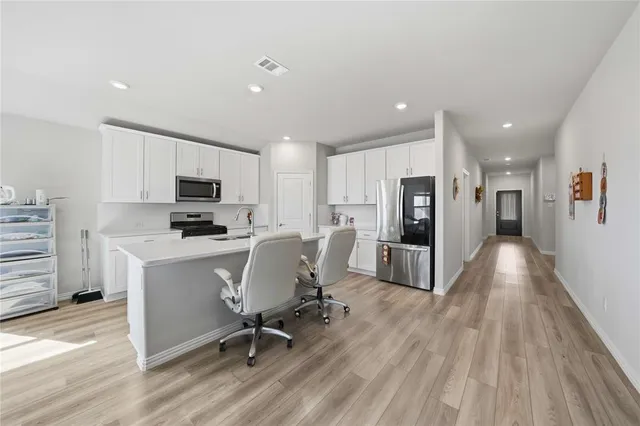 a view of kitchen with refrigerator microwave and wooden floor
