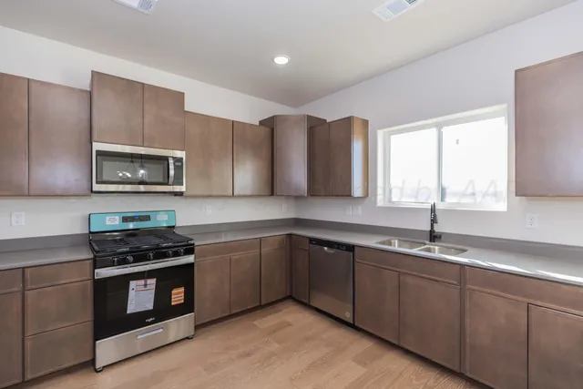 a kitchen with stainless steel appliances granite countertop a stove a sink and a microwave