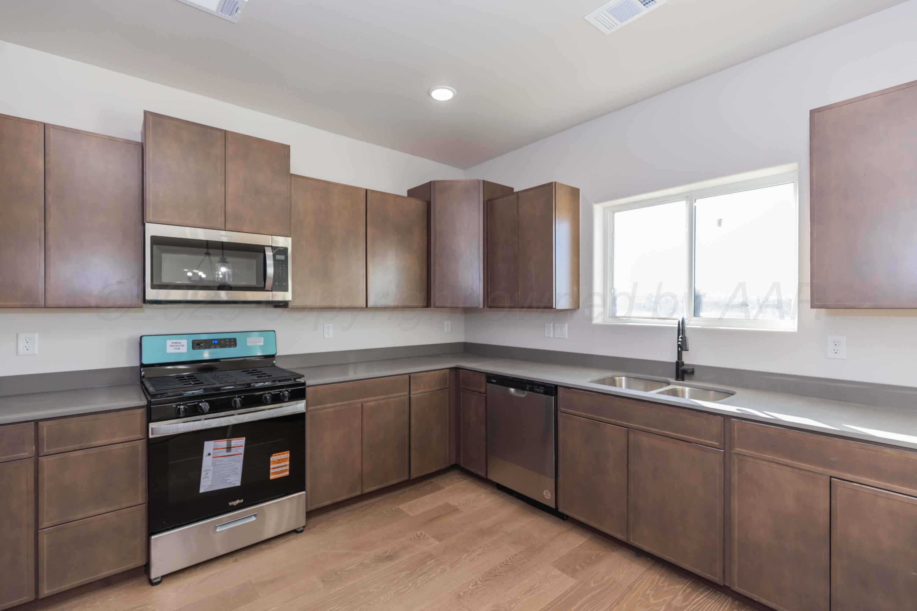 1205 Cabernet Way Amarillo, TX 79124 - Photo 4 of 13 a kitchen with stainless steel appliances granite countertop a stove a sink and a microwave