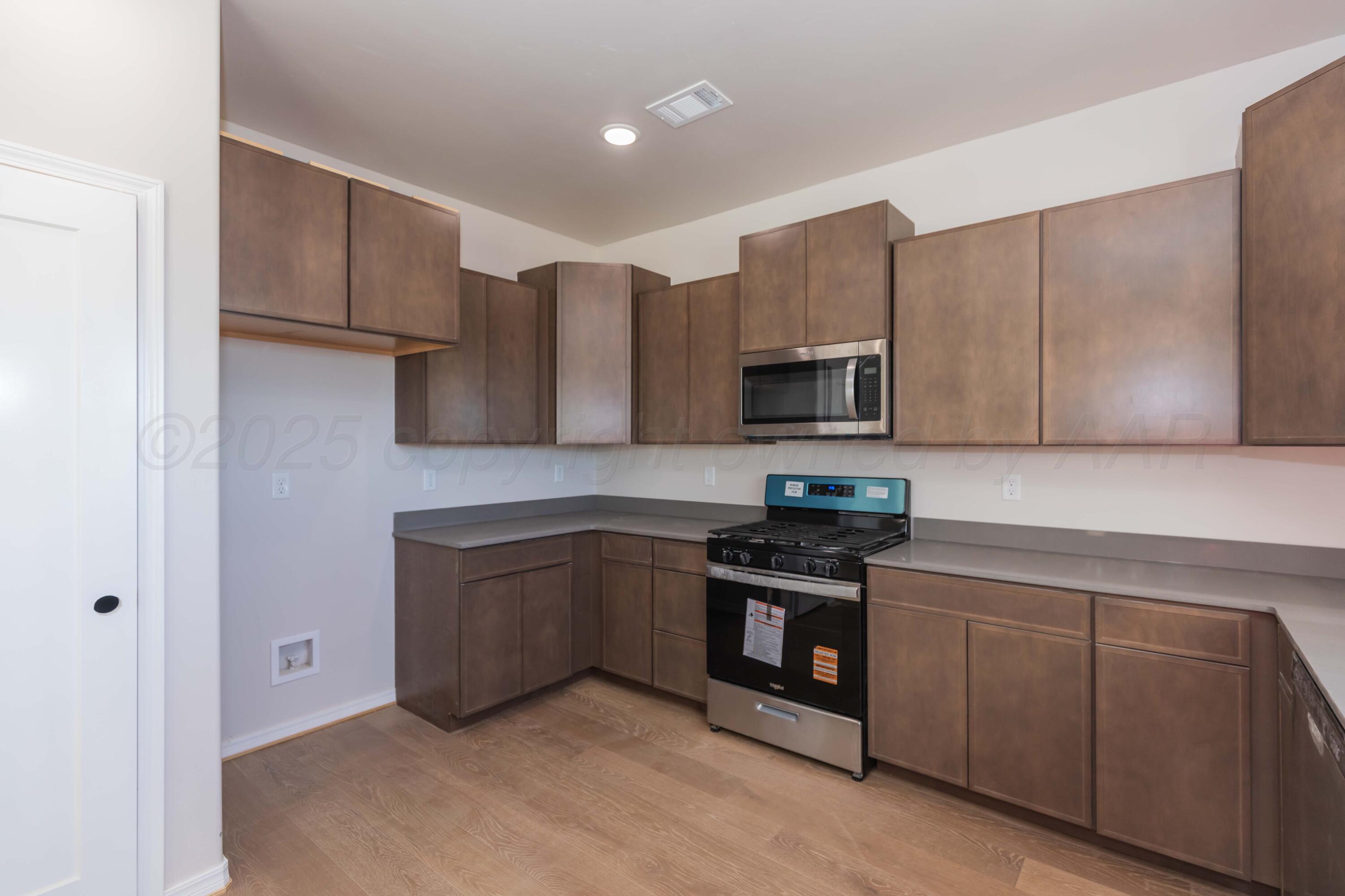 1205 Cabernet Way Amarillo, TX 79124 - Photo 5 of 13 a kitchen with stainless steel appliances granite countertop a stove a sink and a microwave