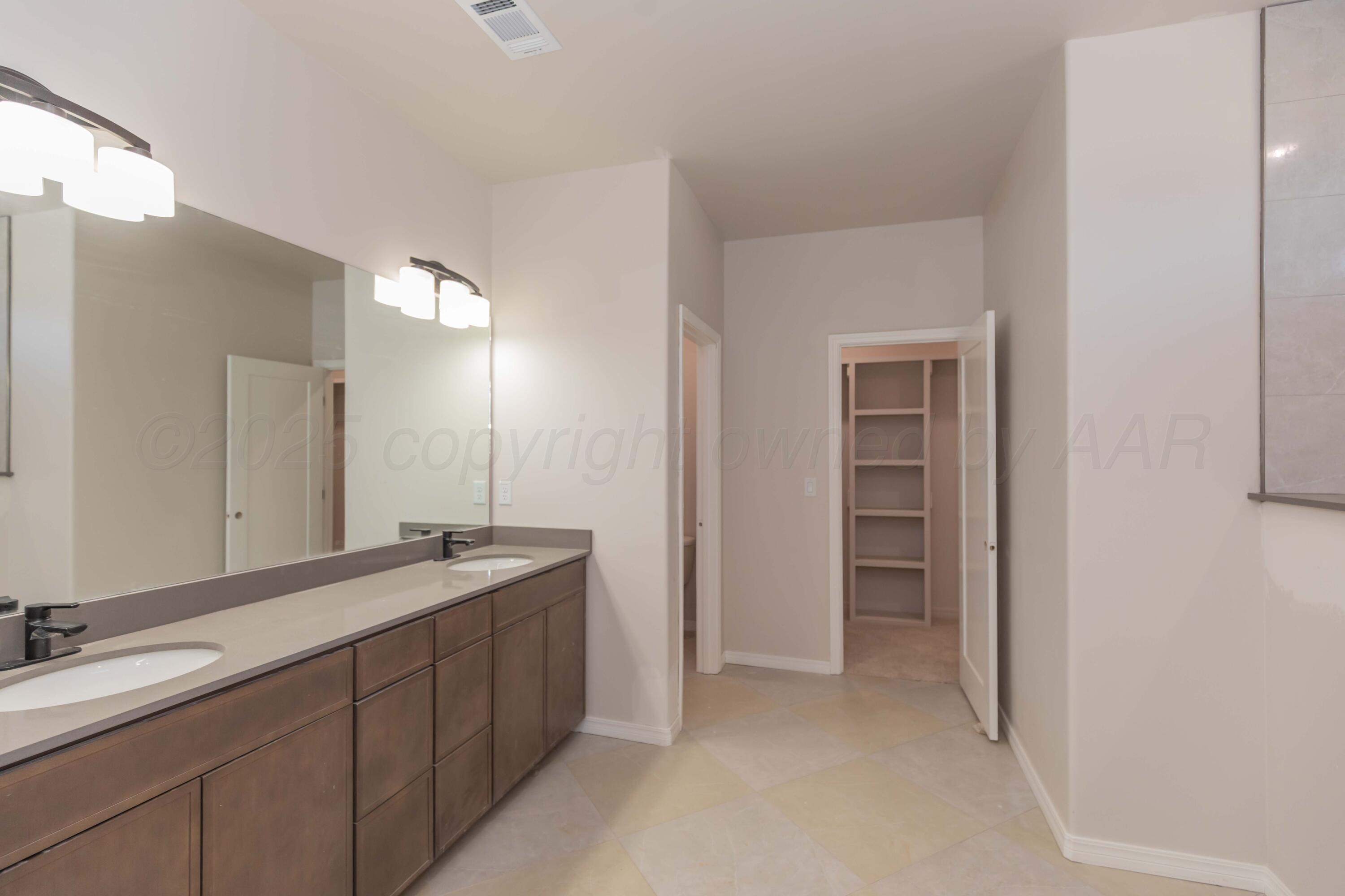1205 Cabernet Way Amarillo, TX 79124 - Photo 8 of 13 a spacious bathroom with a double vanity sink and a mirror