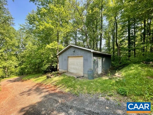 533 Simms Road Stanardsville, VA 22973 - Photo 17 of 17 a backyard of a house with large trees and brick wall