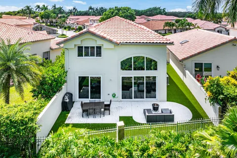 a view of backyard with seating area and trees in the background