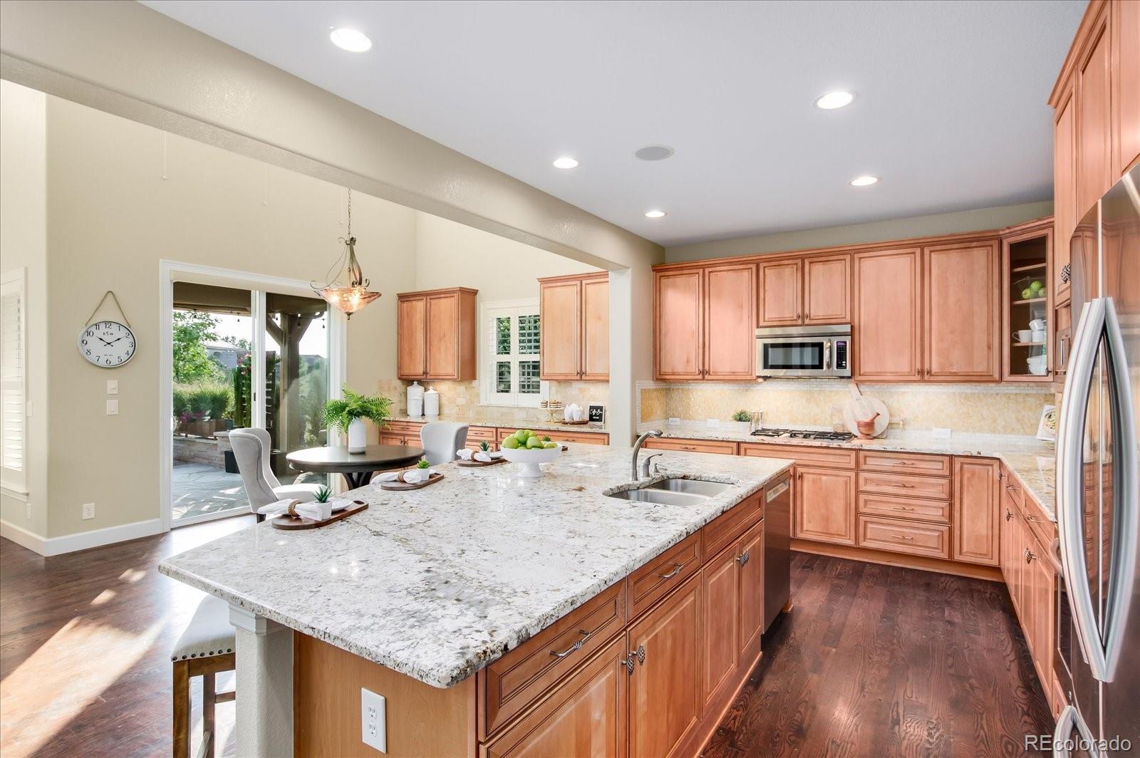 470 Maplehurst Drive Highlands Ranch, CO 80126 - Photo 12 of 40 a kitchen with stainless steel appliances granite countertop sink stove and wooden cabinets