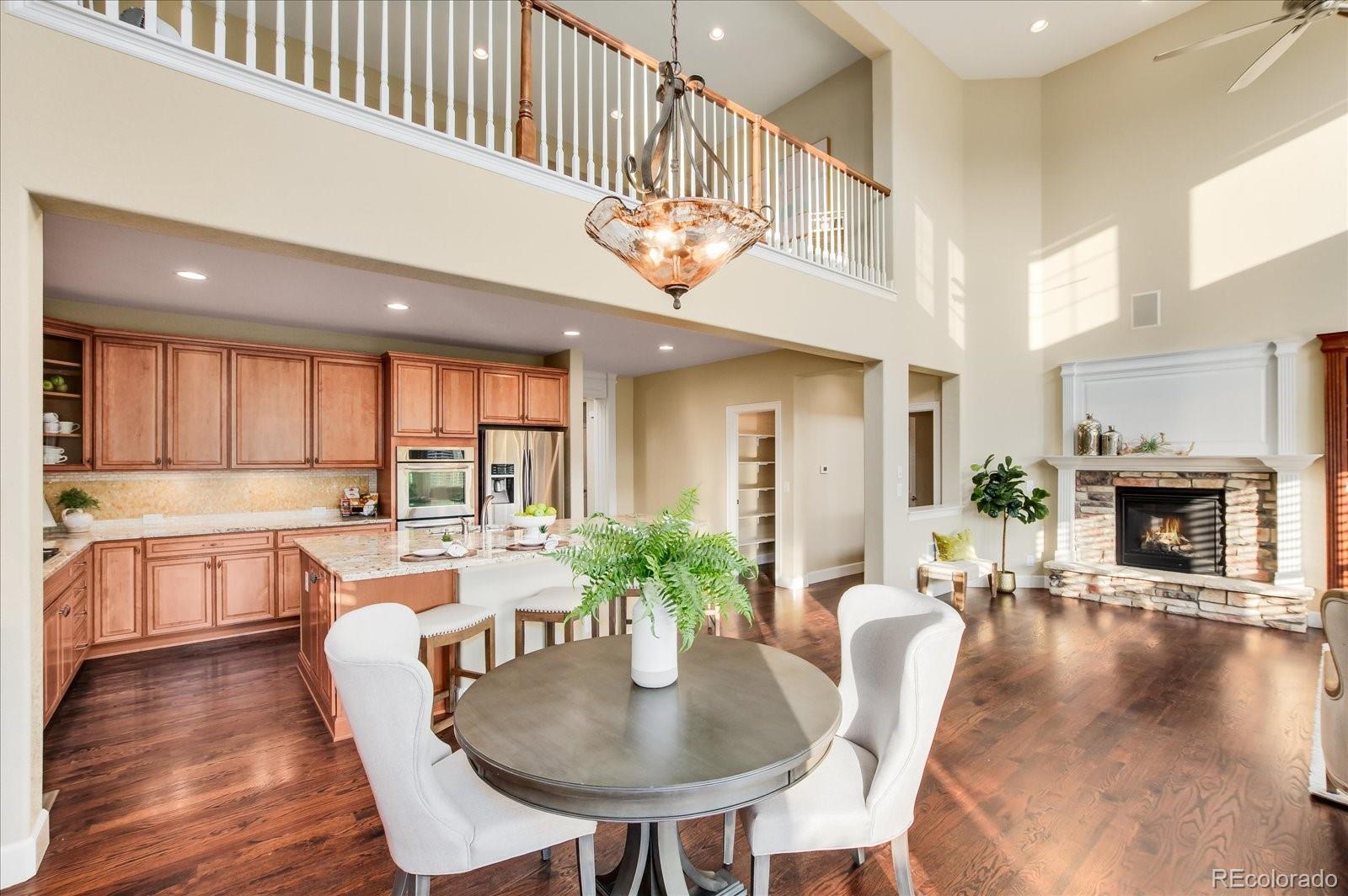 470 Maplehurst Drive Highlands Ranch, CO 80126 - Photo 14 of 40 a large white kitchen with granite countertop a stove a table and chairs