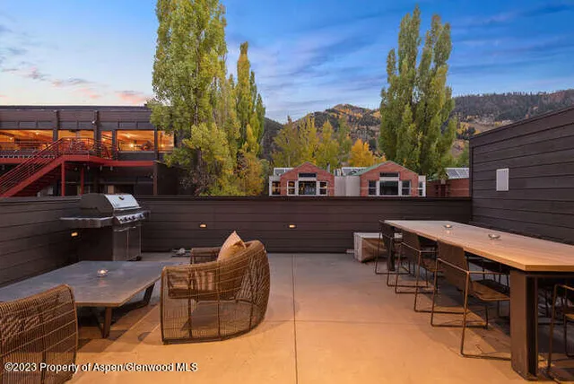 a backyard of a house with barbeque oven table and chairs